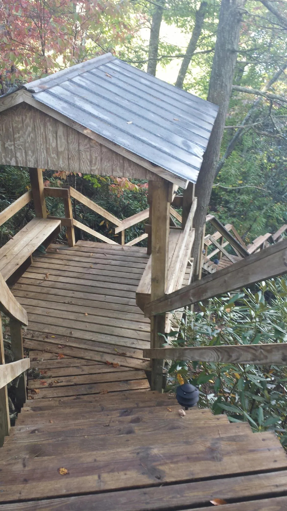 Metal roofed shelter over wooden steps on a wooded walkway — Skylight Repair & Installation work by our crew in Nashville
